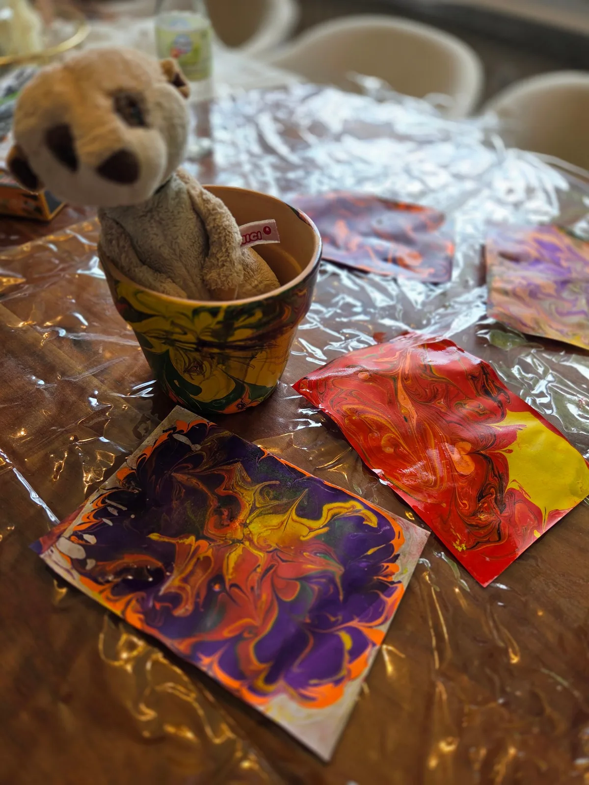 Ebru-Malsachen: bunte Farbflaschen, Pinsel und eine Wanne mit Marmormuster